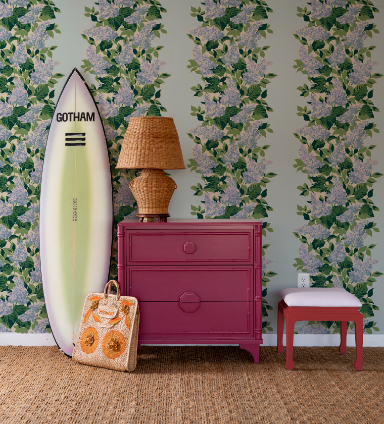 surfbooard and pink chest against a blue and pink wallpaper featuring a leafy hydrangea motif.