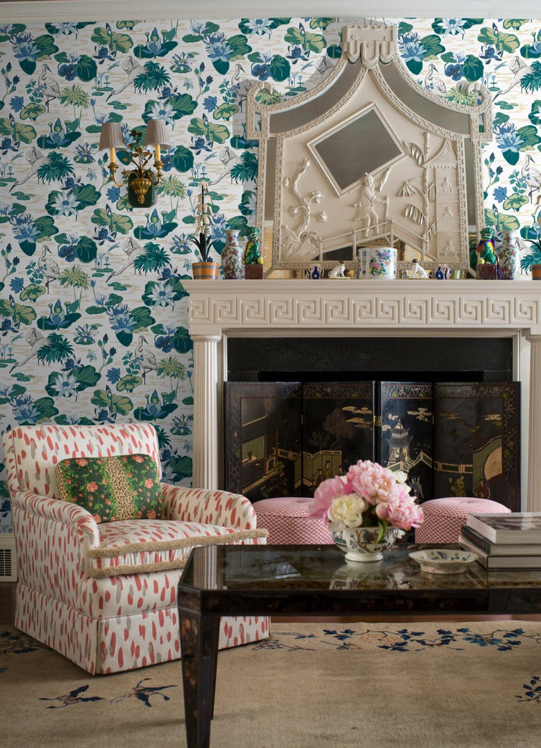 lounge room featuring a wall of green and blue wallpaper and a fireplace.