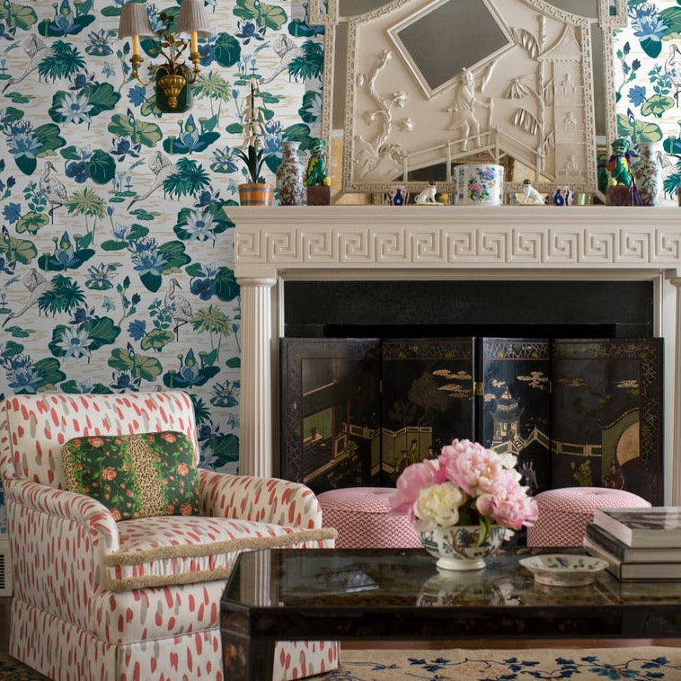 lounge room featuring a wall of green and blue wallpaper and a fireplace.