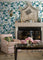 lounge room featuring a wall of green and blue wallpaper and a fireplace.