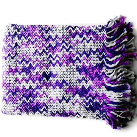 A white and purple throw blanket with a woven zig zag pattern 