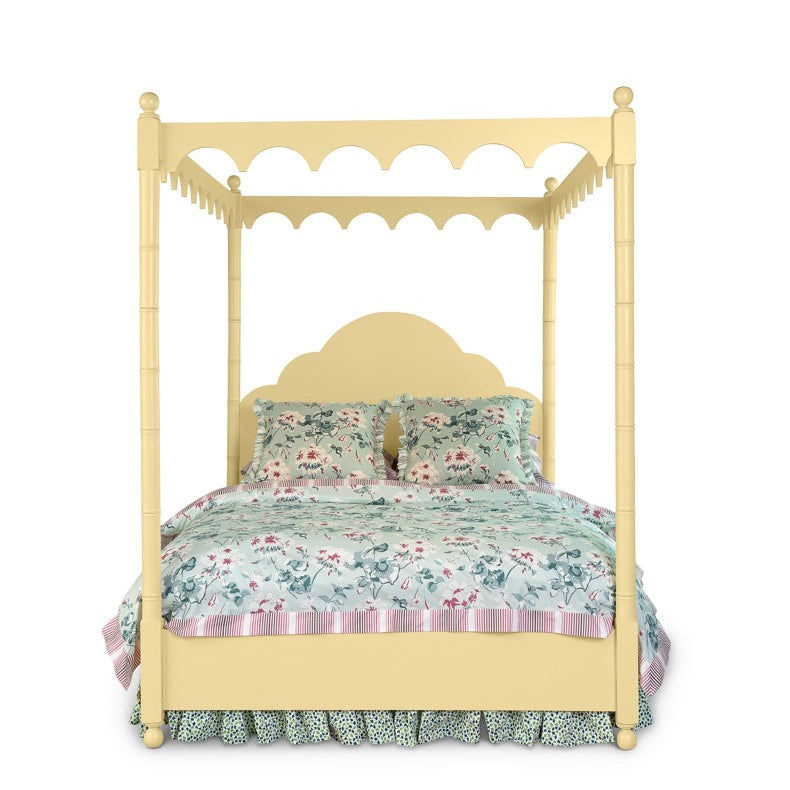 a four poster yellow canopy bed with floral bedding